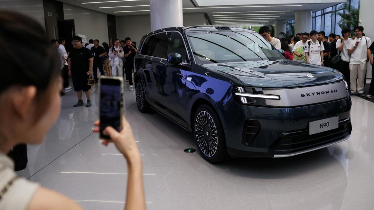 A woman takes photos of a Xiaomi SkyNomad N90 Max EREV (Extended-Range Electric Vehicle) on display before the car's launch event, in Xiaomi's industrial park, in Beijing, China July 30, 2026. REUTERS/Tingshu Wang