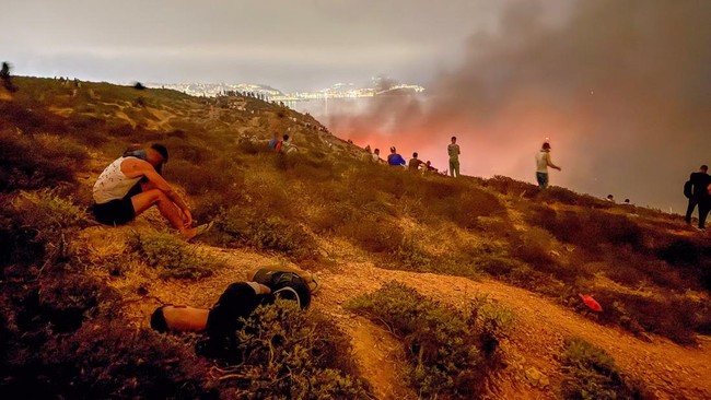 Migrants rest as they wait for a chance to cross to the Spanish enclave of Ceuta, on the Moroccan side of the border in Fnideq, Morocco, July 31, 2026. Picture taken with a mobile phone. REUTERS/Stringer     TPX IMAGES OF THE DAY
