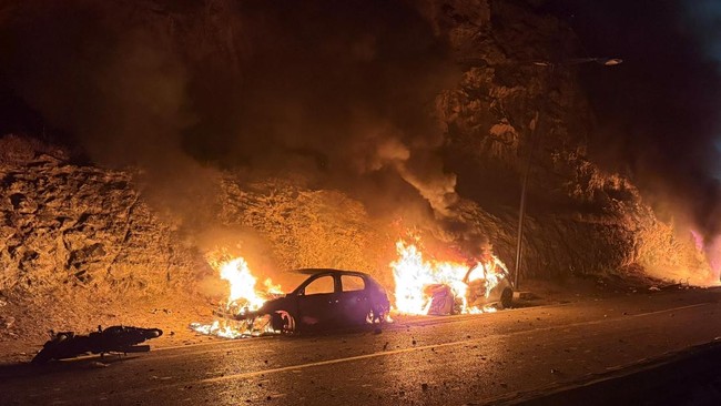 Two cars burn as migrants wait for a chance to cross to the Spanish enclave of Ceuta, on the Moroccan side of the border in Fnideq, Morocco, July 31, 2026. Picture taken with a mobile phone. REUTERS/Stringer
