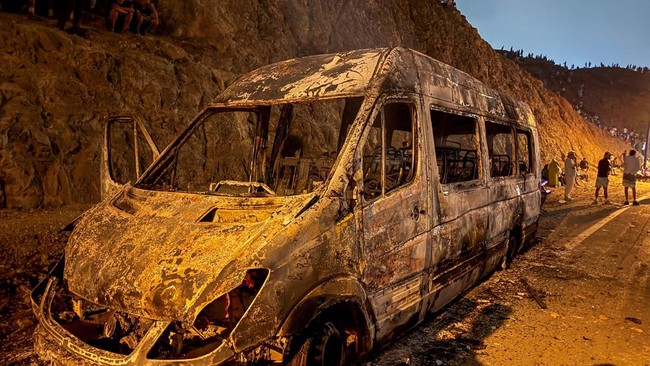A burned vehicle as migrants wait for a chance to cross to the Spanish enclave of Ceuta, on the Moroccan side of the border in Fnideq, Morocco, July 31, 2026. Picture taken with a mobile phone. REUTERS/Stringer