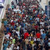 Police officers and Spanish soldiers escort a big group of migrants to the border to take them out of Spain, after mass crossings of migrants on foot and by sea from Morocco into Spanish territory, in Ceuta, Spain, August 1, 2026. REUTERS/Jon Nazca