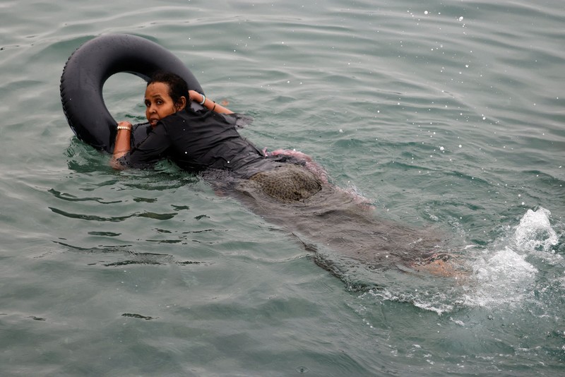 Migrants walk on the Moroccan side of the border, after mass crossings of migrants on foot and by sea from Morocco into Spanish territory, as seen from Cueta, Spain, August 1, 2026. REUTERS/Jon Nazca