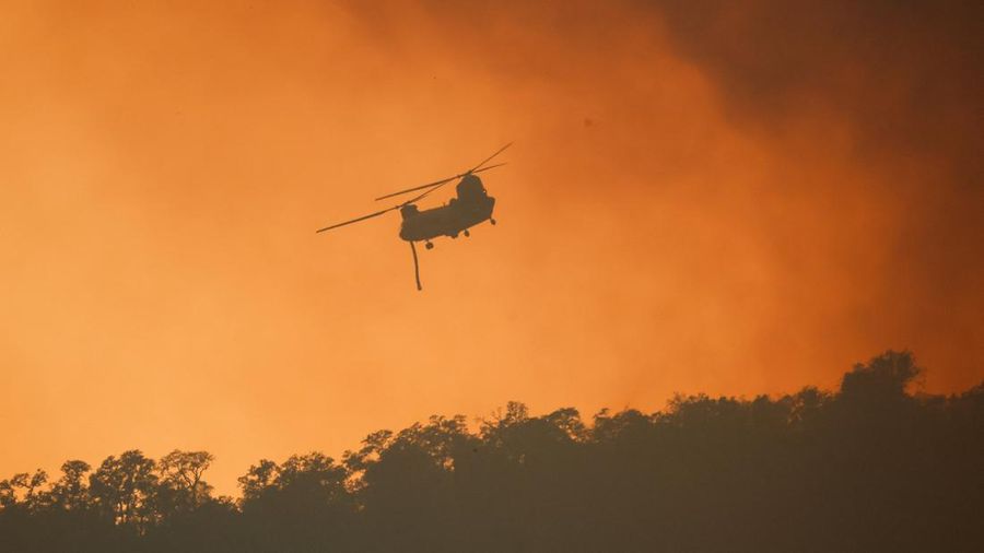 A firefighting helicopter flies through a smoke from the Feliz Fire, near Hopland, California, U.S., August 1, 2026. REUTERS/Fred Greaves