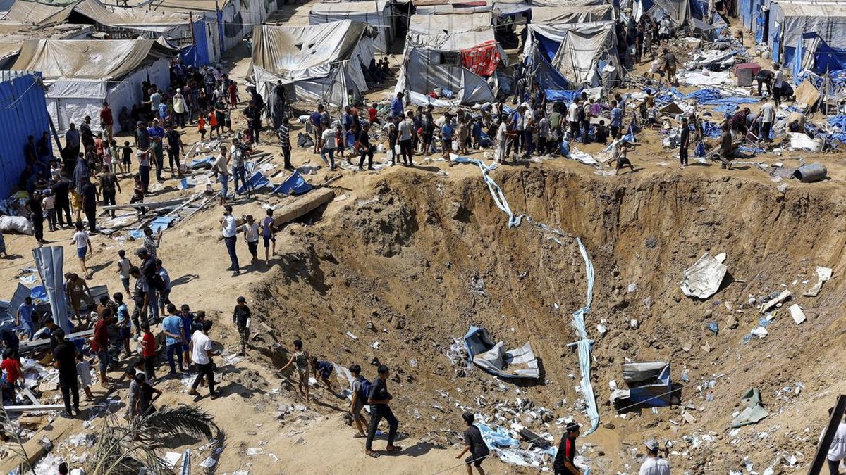 Palestinians inspect the site of an overnight Israeli strike on a medicine warehouse,  according to medics, next to tents sheltering displaced Palestinians, in Deir al-Balah, in the central Gaza Strip, August 1, 2026, residents had been pre-warned by
