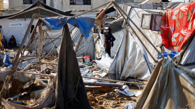 A woman stands near tents sheltering displaced Palestinians, following an overnight Israeli strike on a medicine warehouse, according to medics, in Deir al-Balah, in the central Gaza Strip, August 1, 2026., residents had been pre-warned by the Israel