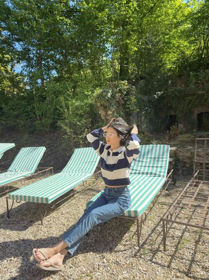 Masih di momen liburan, Song Hye Kyo mengenakan blus garis-garis berpotongan crop dipadupkan dengan straight leg denim./ Foto: instagram.com/kyo1122