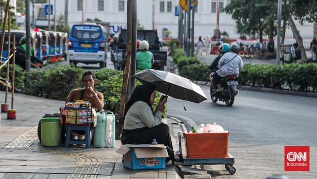 Sejumlah warga beraktivitas di bawah terik matahari di kawasan Sudirman, Jakarta, Senin (3/8). (CNN Indonesia/Febria Adha L)