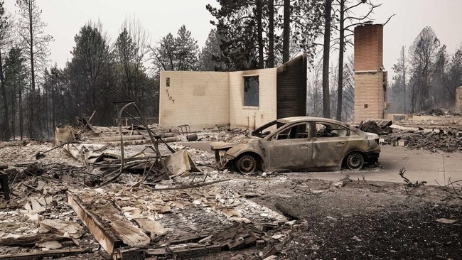 A burned vehicle sits among the remains of a home as wildfires burn in Spokane, Washington, U.S., August 2, 2026. REUTERS/David Ryder