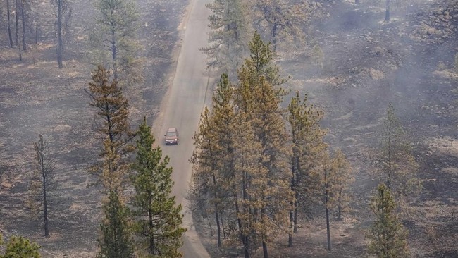 A vehicle drives by as smoke billows from the Old Trails Fire as wildfires burn in Spokane, Washington, U.S., August 2, 2026. REUTERS/David Ryder     TPX IMAGES OF THE DAY