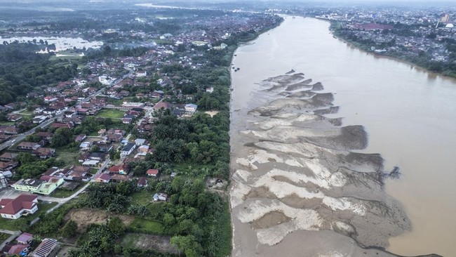 Foto udara permukiman dan hamparan pasir di pinggir Sungai Batanghari yang surut di Tanjung Pasir, Danau Teluk, Jambi, Sabtu (18/7/2026). Sungai terpanjang di Sumatera itu mulai menyusut dan memunculkan hamparan pasir hingga seluas lima hektare lebih