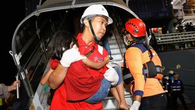 A rescue team member carries a child after Mutiara Sentosa 2 ferry caught fire off Indonesia's Madura island, at Tanjung Perak port in Surabaya, East Java province, Indonesia, August 3, 2026. REUTERS/Dipta Wahyu