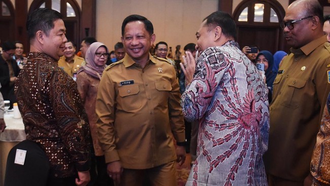 Menteri Dalam Negeri Tito Karnavian (kedua kiri) berbincang dengan Dirjen Dukcapil Kemendagri Teguh Setyabudi (kiri) saat menghadiri pembukaan.