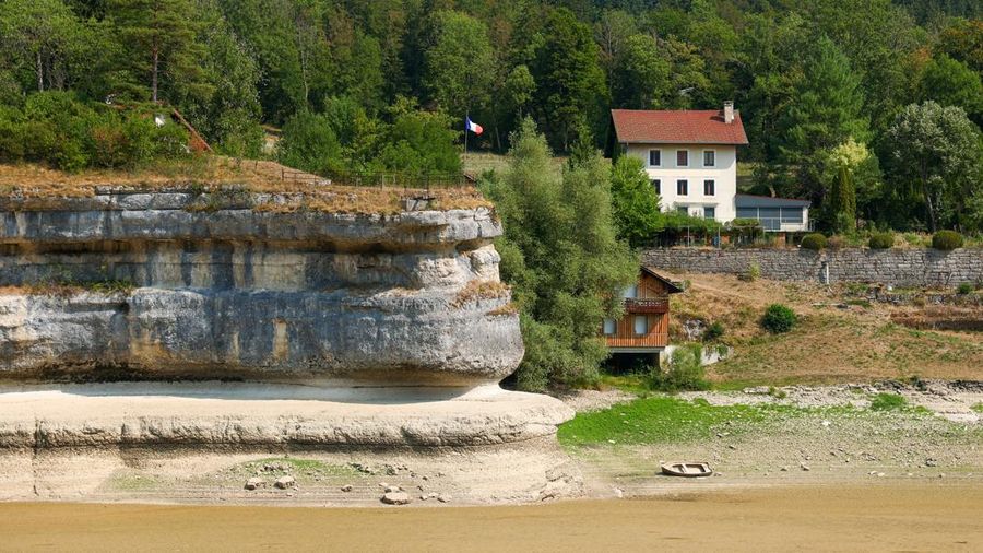 Sebuah bendera Prancis terlihat berkibar di tebing di Danau Brenet nan nyaris kosong, lantaran kondisi kekeringan nan melanda Sungai Doubs menurunkan permukaan air di perbatasan Swiss-Prancis di Les Brenets, Swiss, 30 Juli 2026.