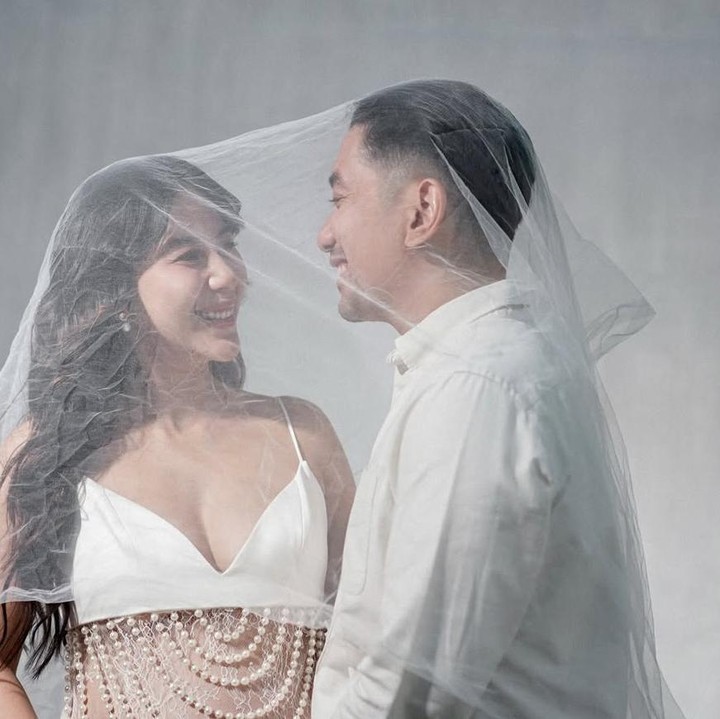 <p>Tak hanya itu, momen romantis juga ditampilkan di maternity shoot Adinda dan Raka. Keduanya berpose di balik kain tulle transparan dengan saling menatap sambil mengusap baby bump yang kini sudah besar di trimester ketiga. (Foto: @adindathomas)</p>