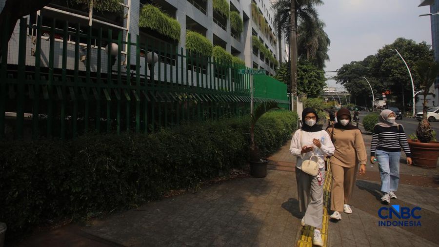 Warga melintas di samping pagar Blok M Plaza, Jakarta, Senin (3/8/2026). Polemik pemasangan pagar tinggi di sejumlah pusat perbelanjaan di Jakarta mencuri perhatian setelah beberapa mal memasang pagar besi nan mengelilingi area bangunan. (CNBC Indon