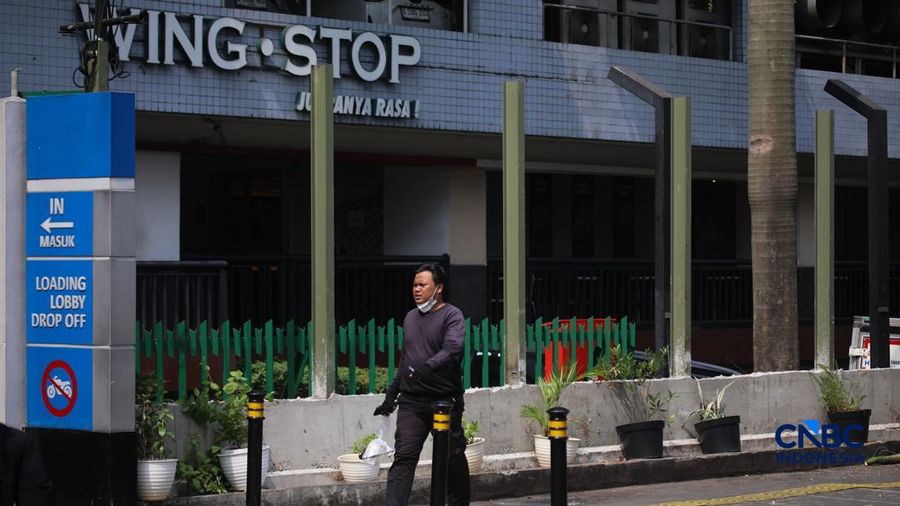 Warga melintas di samping pagar Blok M Plaza, Jakarta, Senin (3/8/2026). Polemik pemasangan pagar tinggi di sejumlah pusat perbelanjaan di Jakarta mencuri perhatian setelah beberapa mal memasang pagar besi nan mengelilingi area bangunan. (CNBC Indon
