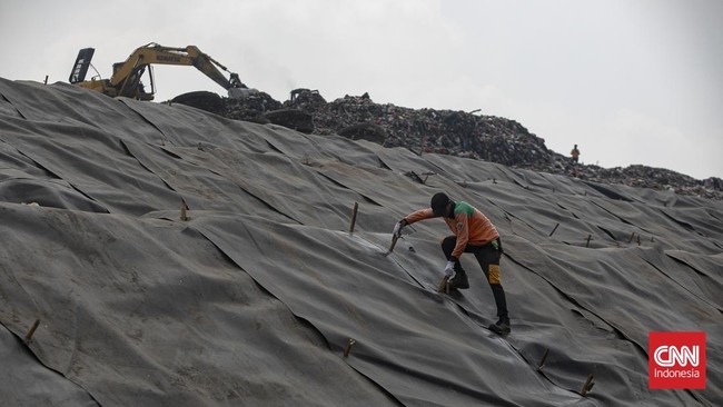Petugas memasang patok pada geomembran sebagai media pelindung untuk menutup tumpukan sampah di Tempat Pengolahan Sampah Terpadu (TPST) Bantargebang, Kota Bekasi, Jawa Barat, Selasa (4/8/2026). (CNN Indonesia/Adi ibrahim)