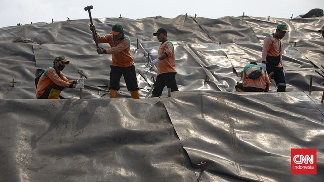 Petugas memasang patok pada geomembran sebagai media pelindung untuk menutup tumpukan sampah di Tempat Pengolahan Sampah Terpadu (TPST) Bantargebang, Kota Bekasi, Jawa Barat, Selasa (4/8/2026). (CNN Indonesia/Adi ibrahim)