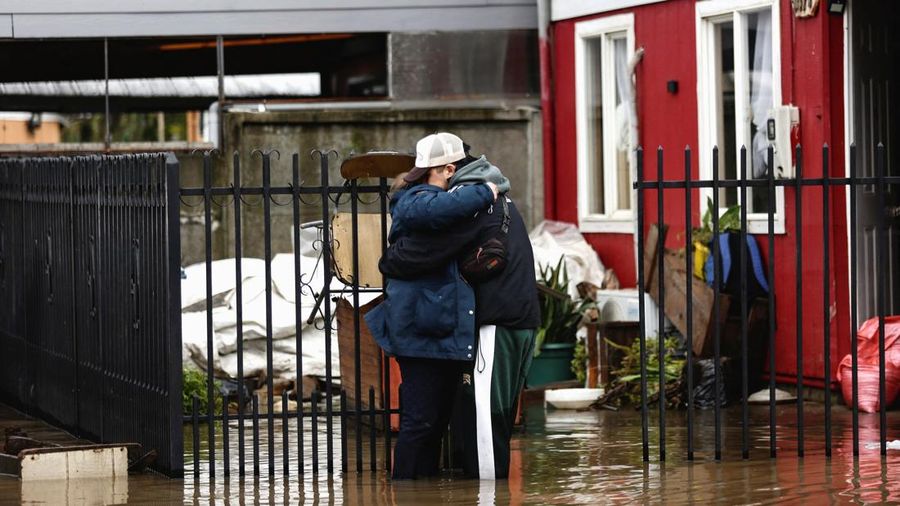 Warga saling berpelukan sembari berdiri di tengah air banjir setelah angin besar membawa hujan lebat dan menyebabkan banjir di Angol, Chili, 3 Agustus 2026.