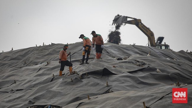 Petugas memasang patok pada geomembran sebagai media pelindung untuk menutup tumpukan sampah di Tempat Pengolahan Sampah Terpadu (TPST) Bantargebang, Kota Bekasi, Jawa Barat, Selasa (4/8/2026). (CNN Indonesia/Adi ibrahim)