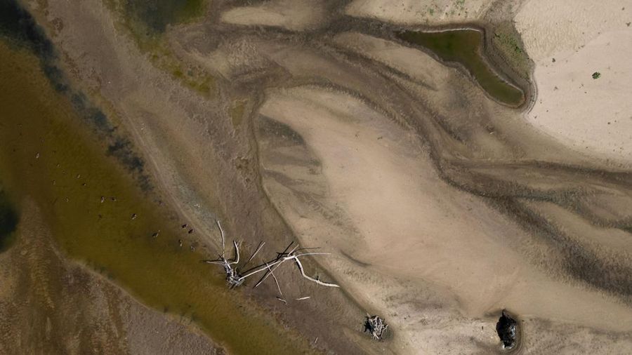 Tampilan dari drone memperlihatkan gosong pasir nan muncul di permukaan Sungai Vistula dekat Jozefow—di pinggiran Warsawa, Polandia, pada 4 Agustus 2026—akibat gelombang panas nan menyebabkan penurunan permukaan air sungai di beragam wilayah negara tersebut.