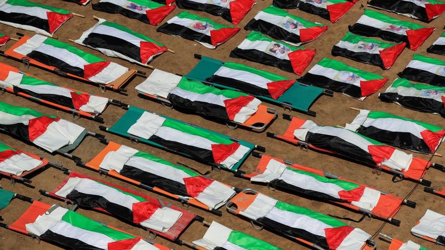 Warga Gaza menggelar pemakaman jenazah 112 personil satu family besar nan tewas dalam agresi Israel nyaris tiga tahun lalu, Selasa (4/8/2026). (via REUTERS/Dawoud Abu Alkas)