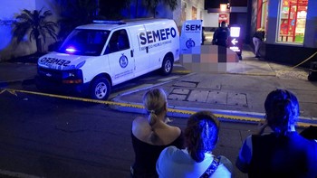 Onlookers stand behind a police cordon as forensic technicians and police officers work at the crime scene where Mexican social media influencer Cesar Gastelum, known for his comedy videos and followed by nearly 600,000 people on TikTok, was shot and
