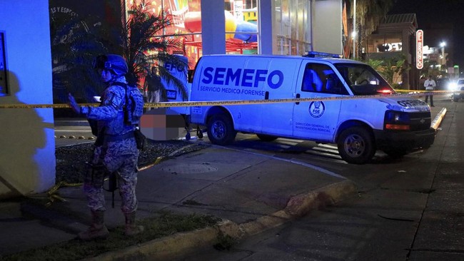 A soldier stands guard as forensic technicians and police officers work at the crime scene where Mexican social media influencer Cesar Gastelum, known for his comedy videos and followed by nearly 600,000 people on TikTok, was shot and killed while li