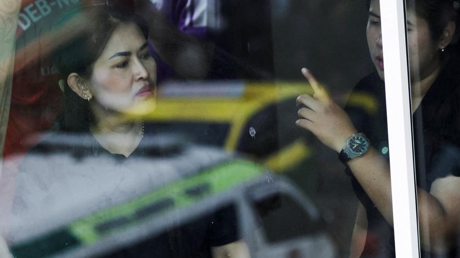 Bayangan ambulans terlihat pada pantulan kaca jendela saat para pembimbing dari sekolah di dekatnya mengawasi situasi di Sekolah Debsirin Nonthaburi—lokasi terjadinya kejadian penembakan—di distrik Bang Kruai, Provinsi Nonthaburi, di pinggiran Bangkok, Thailand, pada 7 Agustus 2026.