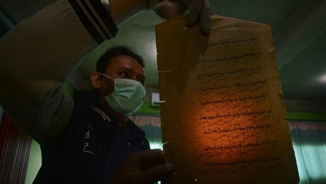 Petugas membersihkan kitab kuno saat melakukan digitalisasi pengarsipan di Pondok Pesantren Yayasan Zumrotut Tholibin, Andong, Boyolali, Jawa Tengah, Jumat (7/8/2026). Dinas Arsip dan Perpustakaan bersama Dinas Pendidikan dan Kebudayaan Kabupaten Boy
