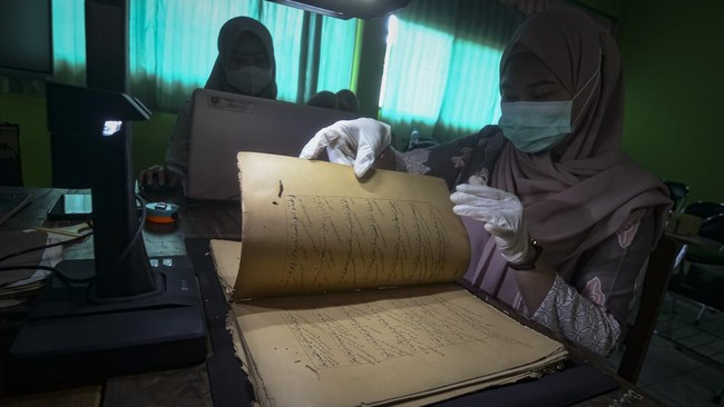 Petugas membersihkan kitab kuno saat melakukan digitalisasi pengarsipan di Pondok Pesantren Yayasan Zumrotut Tholibin, Andong, Boyolali, Jawa Tengah, Jumat (7/8/2026). Dinas Arsip dan Perpustakaan bersama Dinas Pendidikan dan Kebudayaan Kabupaten Boy