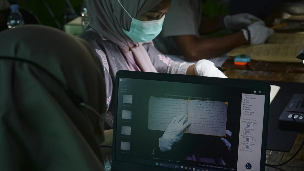 Petugas membersihkan kitab kuno saat melakukan digitalisasi pengarsipan di Pondok Pesantren Yayasan Zumrotut Tholibin, Andong, Boyolali, Jawa Tengah, Jumat (7/8/2026). Dinas Arsip dan Perpustakaan bersama Dinas Pendidikan dan Kebudayaan Kabupaten Boy