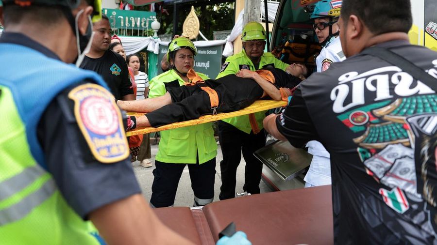 Petugas darurat membawa seorang pembimbing nan terluka ke dalam ambulans di Sekolah Debsirin Nonthaburi—lokasi terjadinya kejadian penembakan—di Distrik Bang Kruai, Provinsi Nonthaburi, di pinggiran Bangkok, Thailand, pada 7 Agustus 2026.