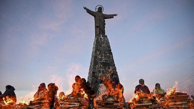 People watch ritual offerings being consumed by fire during ceremonies for the Month of Pachamama, as Bolivians make offerings to Mother Earth to seek health, prosperity and good harvests, in La Cumbre, on the outskirts of La Paz, Bolivia, August 1,