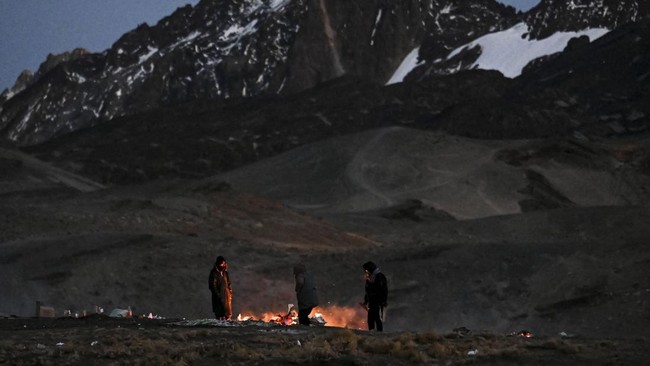 People watch ritual offerings as they are consumed by fire during ceremonies for the Month of Pachamama, as Bolivians make offerings to Mother Earth to seek health, prosperity and good harvests, in La Cumbre, on the outskirts of La Paz, Bolivia, Augu