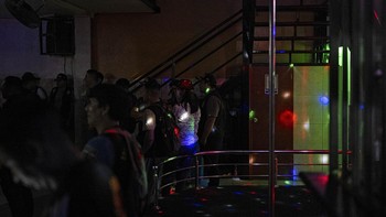 Sex workers wait to undergo an identity check during an anti-human trafficking police operation called Sodom and Gomorrah at La Miel brothel, in the Independencia district, on the northern outskirts of Lima on July 31, 2026 late night. (Photo by ERNE