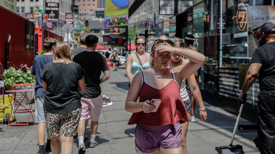 Seorang wanita melindungi wajahnya dari sinar mentari dengan tangannya saat gelombang panas melanda New York City, AS, pada 6 Agustus 2026.
