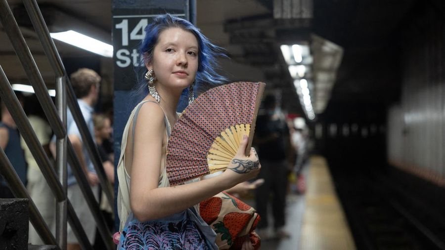 Seorang wanita mengipasi dirinya di stasiun kereta bawah tanah saat gelombang panas melanda New York City, AS, pada 7 Agustus 2026.