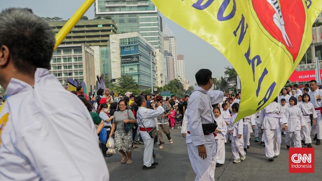 Sejumlah pesilat dari berbagai perguruan mengikuti kerumun kilas saat Hari Bebas Kendaraan Bermotor (HBKB) di Bundaran HI, Jakarta, Minggu (9/8). (CNN Indonesia/Febria Adha L)