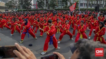 Sejumlah pesilat dari berbagai perguruan mengikuti kerumun kilas saat Hari Bebas Kendaraan Bermotor (HBKB) di Bundaran HI, Jakarta, Minggu (9/8). (CNN Indonesia/Febria Adha L)