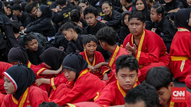 Sejumlah pesilat dari berbagai perguruan mengikuti kerumun kilas saat Hari Bebas Kendaraan Bermotor (HBKB) di Bundaran HI, Jakarta, Minggu (9/8). (CNN Indonesia/Febria Adha L)