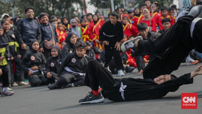 Sejumlah pesilat dari berbagai perguruan mengikuti kerumun kilas saat Hari Bebas Kendaraan Bermotor (HBKB) di Bundaran HI, Jakarta, Minggu (9/8). (CNN Indonesia/Febria Adha L)