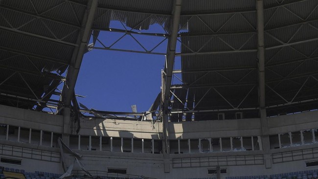 Men look at damage to the Chornomorets Stadium, which was hit by a Russian drone strike, amid Russia's attack on Ukraine, in Odesa, Ukraine, August 7, 2026. REUTERS/Nina Liashonok
