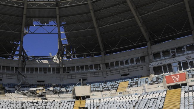 Men look at damage to the Chornomorets Stadium, which was hit by a Russian drone strike, amid Russia's attack on Ukraine, in Odesa, Ukraine, August 7, 2026. REUTERS/Nina Liashonok