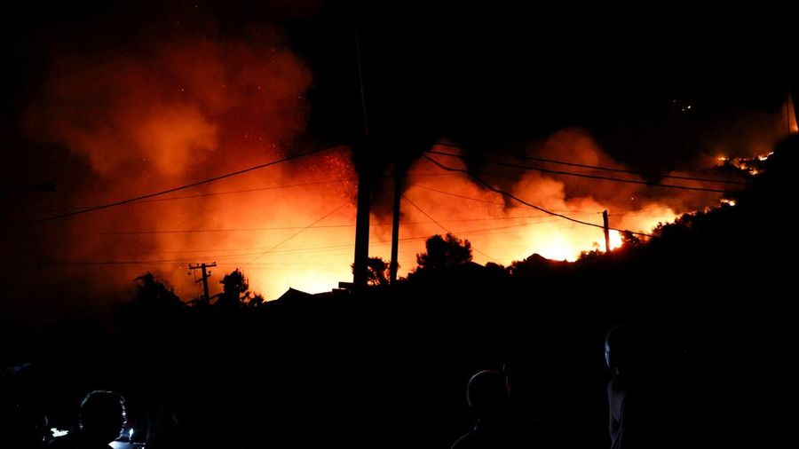 Warga setempat menyaksikan asap membubung dari kebakaran rimba nan melanda Kruja, Albania, pada 9 Agustus 2026. (REUTERS/Florion Goga)