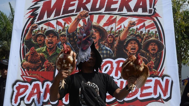Peserta aksi yang tergabung Paguyuban Peternak Boyolali Bersatu mengenakan topeng ayam dan membawa ayam saat melakukan aksi damai membagi ayam dan telur gratis di Boyolali, Jawa Tengah, Senin (10/8/2026). Aksi damai dengan membagi ayam dan telur grat