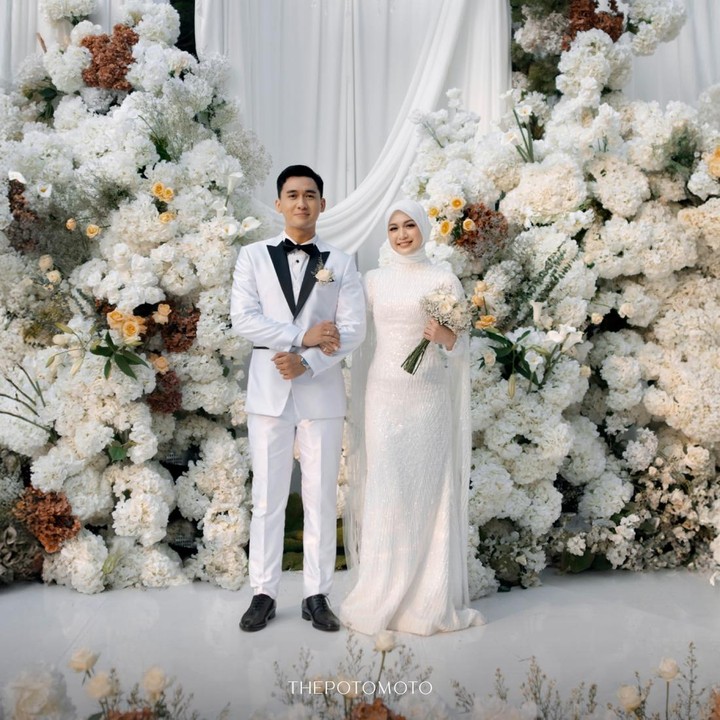 <p>Dekorasi pernikahan pasangan yang satu ini didominasi dengan warna putih. Nuansa tersebut terlihat pada rangkaian bunga, kursi tamu undangan, hingga area pelaminan. Tak hanya dekorasinya, keduanya juga tampil menawan dalam balutan busana serba putih&nbsp;(Foto: Instagram @deaaannisa/@thepotomoto)</p>