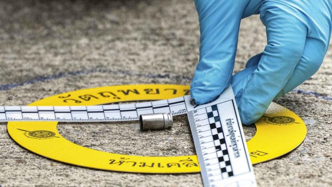 A forensic police officer inspects the site of a shooting after former lawmaker Chalong Riewrang allegedly shot Thongchai Yenprasert, president of the Nonthaburi Provincial Administrative Organisation, in Nonthaburi province, on the outskirts of Bang