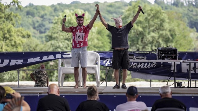 Participants in the French pig-squealing championship perform on stage at the 43rd edition of the Pig Festival, in Trie-sur-BaÔse, south-western France, on August 9, 2026. (Photo by Valentine CHAPUIS / AFP)