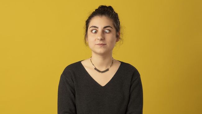 Photo portrait of Squint woman wearing striped t-shirt on yellow background